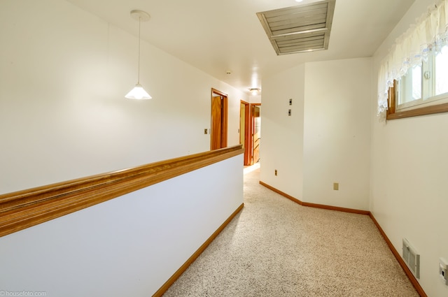 hallway with baseboards and visible vents