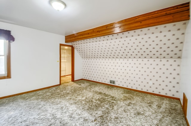 bonus room with baseboards, lofted ceiling, visible vents, and carpet