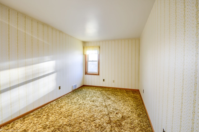 carpeted empty room featuring visible vents
