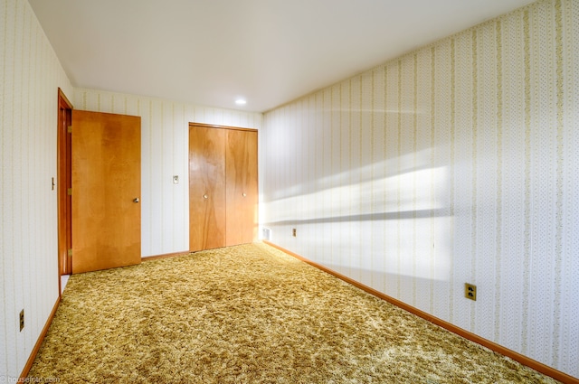 interior space featuring carpet flooring, wallpapered walls, and a closet
