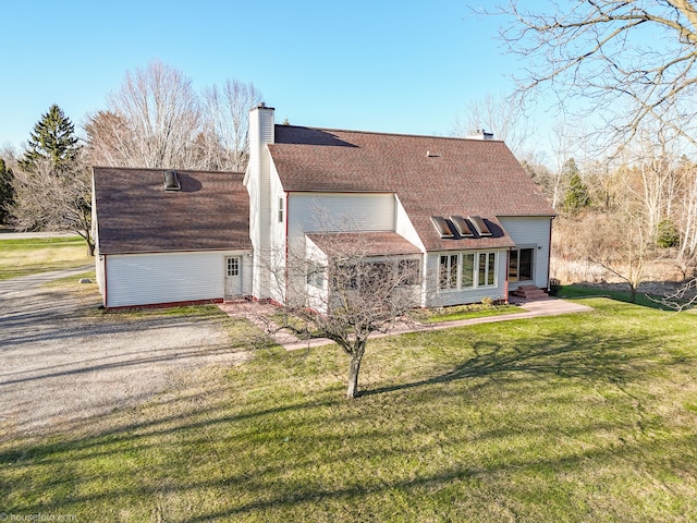 back of property with a lawn, a chimney, and roof with shingles