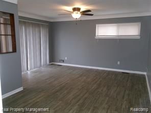 24306 Valley Ave, Eastpointe, MI 48021 - spare room with baseboards, a ceiling fan, and dark wood-style floors
