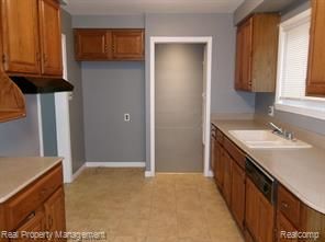 24306 Valley Ave, Eastpointe, MI 48021 - kitchen featuring a sink, brown cabinets, dishwasher, light countertops, and baseboards