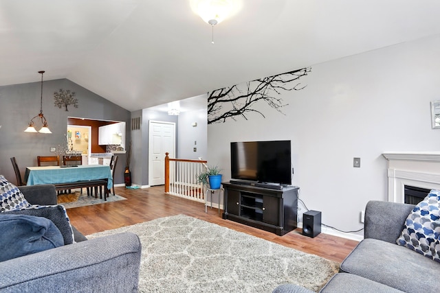 living room with wood finished floors and vaulted ceiling