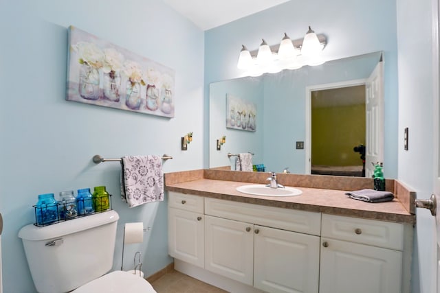 bathroom with toilet, vanity, and tile patterned floors
