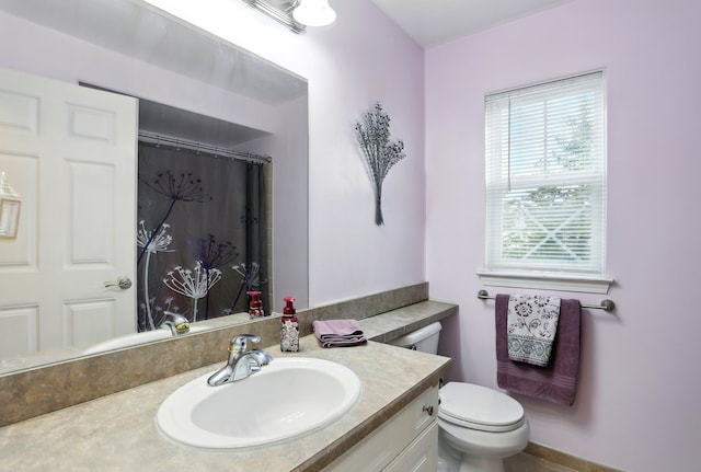 bathroom featuring vanity, toilet, and curtained shower