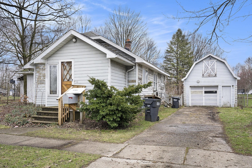 234 E Hammond St, Otsego, MI 49078 - view of front of home featuring a detached garage, an outdoor structure, driveway, and a chimney