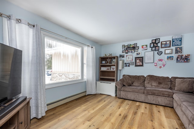living room with light wood finished floors and a baseboard heating unit