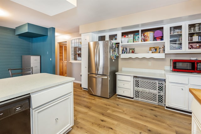 kitchen with freestanding refrigerator, white cabinetry, black dishwasher, light countertops, and light wood finished floors