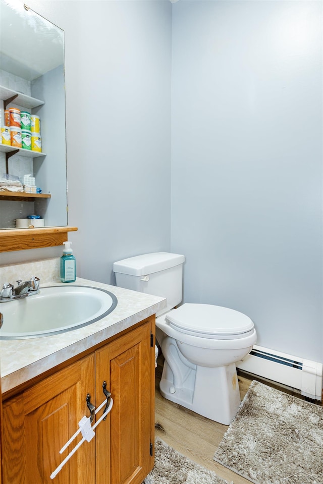 bathroom featuring vanity, baseboard heating, toilet, and wood finished floors