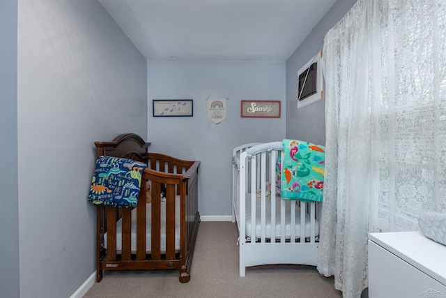 carpeted bedroom with baseboards, a wall mounted AC, and a crib