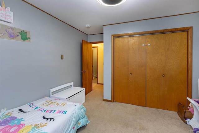 bedroom with light carpet, a closet, and ornamental molding