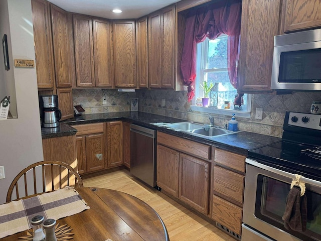 18175 Lake Dr, Big Rapids, MI 49307 - kitchen featuring stainless steel appliances, tasteful backsplash, a sink, and dark countertops