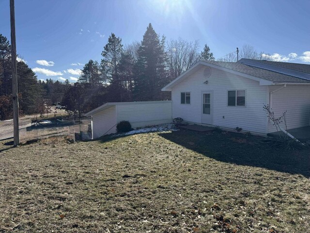 18175 Lake Dr, Big Rapids, MI 49307 - view of property exterior featuring fence and a lawn
