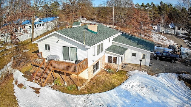 18175 Lake Dr, Big Rapids, MI 49307 - snow covered rear of property with a shingled roof, a deck, and a chimney