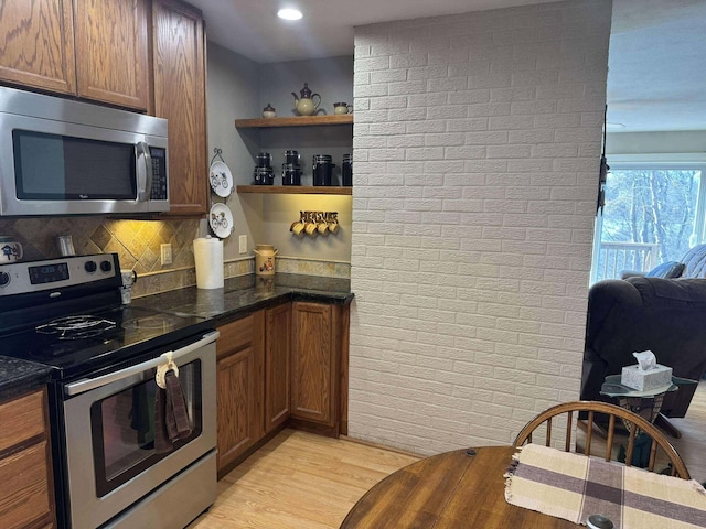 18175 Lake Dr, Big Rapids, MI 49307 - kitchen with open shelves, light wood-style floors, brown cabinetry, stainless steel appliances, and backsplash