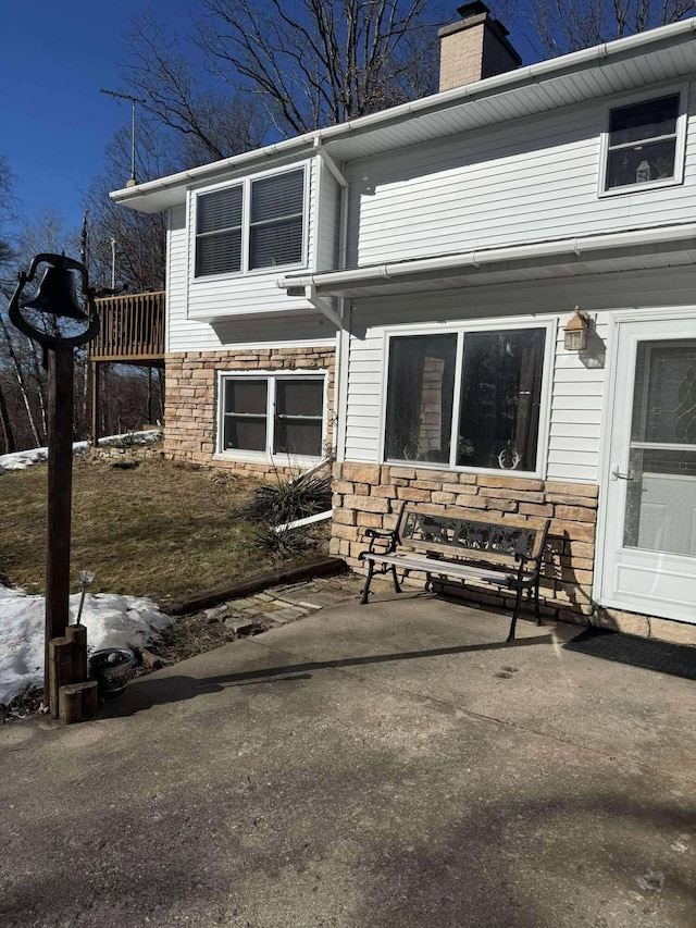 18175 Lake Dr, Big Rapids, MI 49307 - rear view of property with a chimney and stone siding