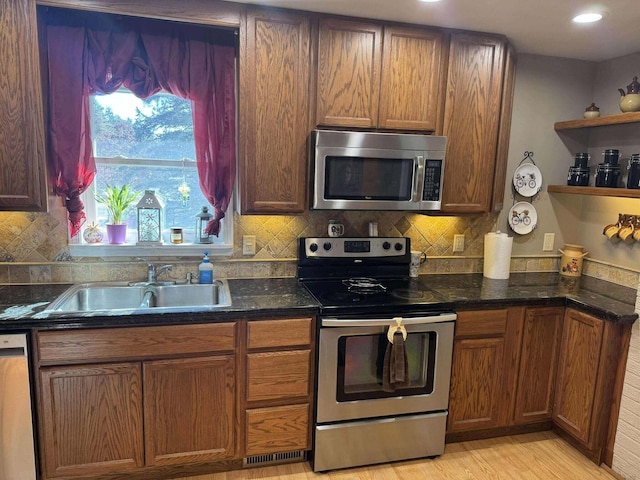 18175 Lake Dr, Big Rapids, MI 49307 - kitchen featuring appliances with stainless steel finishes, open shelves, dark stone counters, decorative backsplash, and a sink