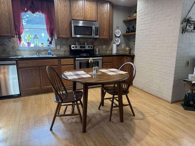 18175 Lake Dr, Big Rapids, MI 49307 - kitchen featuring open shelves, appliances with stainless steel finishes, a sink, dark countertops, and light wood finished floors