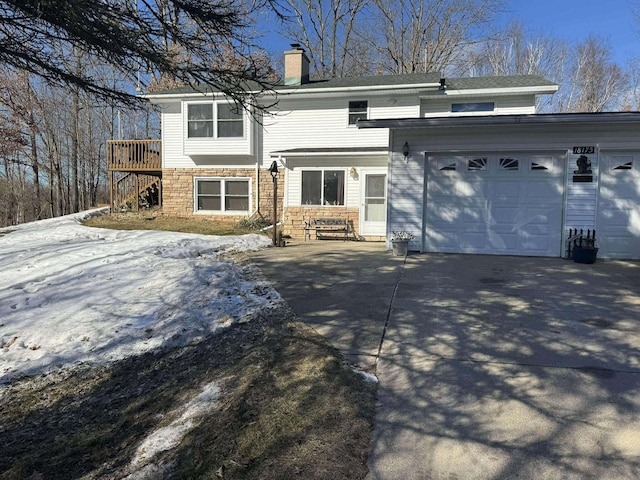 18175 Lake Dr, Big Rapids, MI 49307 - view of front of property with stone siding, stairs, an attached garage, a chimney, and driveway