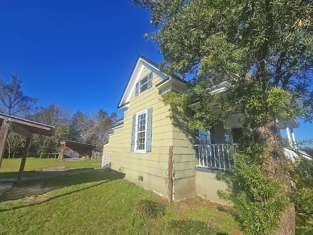 view of side of home with a yard and crawl space