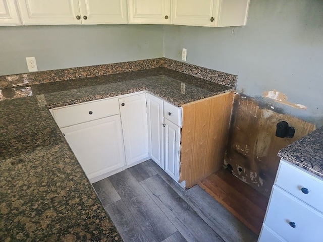 kitchen featuring white cabinets, dark stone counters, and dark wood-style flooring