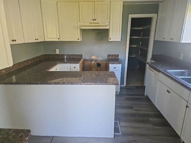 kitchen with a peninsula, dishwasher, under cabinet range hood, and white cabinetry