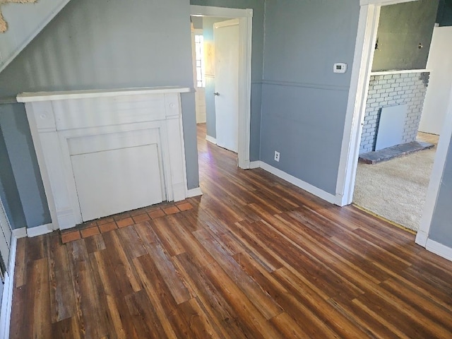 interior space featuring baseboards, dark wood-style floors, and a fireplace