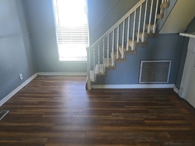 stairway with wood finished floors, visible vents, and baseboards
