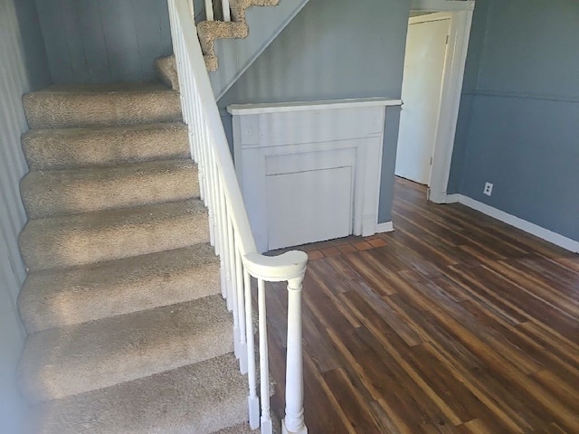staircase with wood finished floors and baseboards