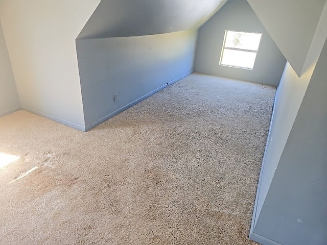 bonus room with vaulted ceiling and carpet flooring