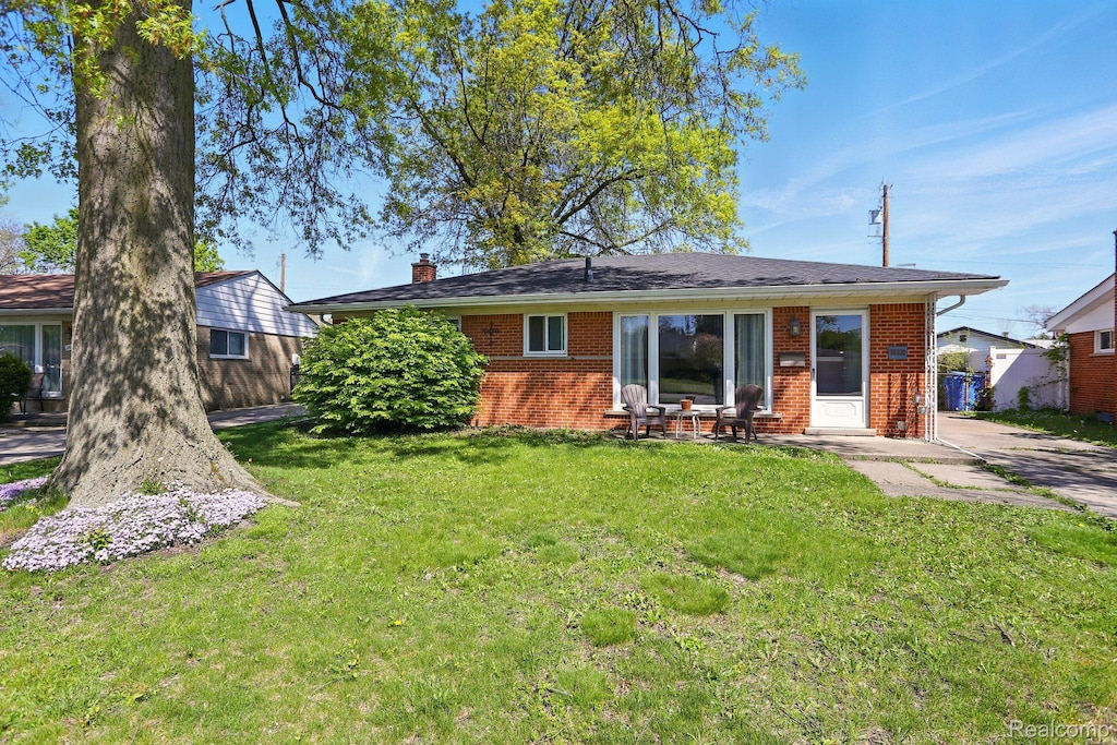 26830 Constance St, Dearborn Heights, MI 48127 - rear view of property with brick siding, a chimney, and a lawn