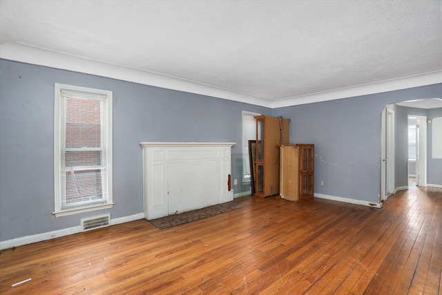 11248 Kennebec, Detroit, MI 48205 - unfurnished living room with wood-type flooring, arched walkways, baseboards, and visible vents