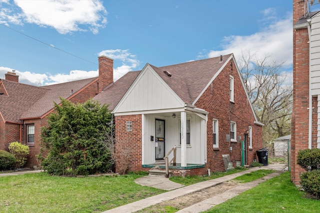 11248 Kennebec, Detroit, MI 48205 - view of front of property with brick siding, a chimney, a shingled roof, and a front lawn
