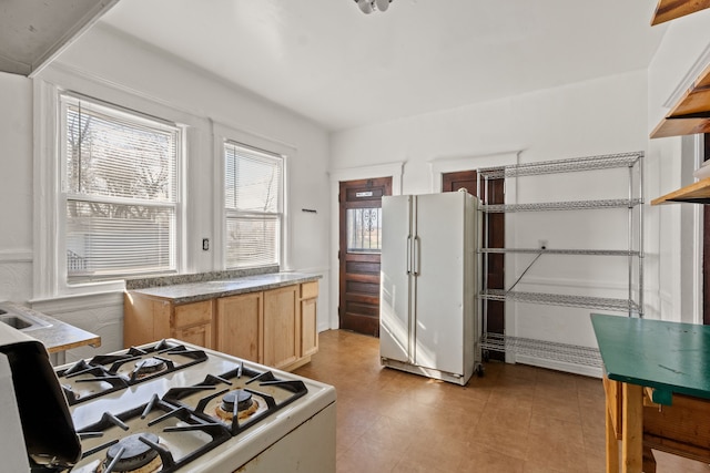 kitchen featuring light brown cabinets and white appliances