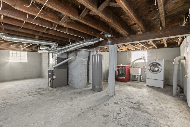 basement featuring washer / clothes dryer, water heater, a sink, and heating unit