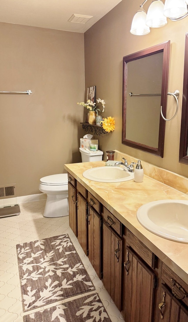 12131 Brandywine Dr, Brighton, MI 48114 - full bath with toilet, double vanity, and baseboards