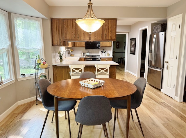 12131 Brandywine Dr, Brighton, MI 48114 - dining area featuring light wood-style flooring and baseboards