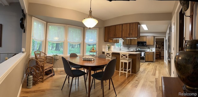 12131 Brandywine Dr, Brighton, MI 48114 - dining area with light wood finished floors, vaulted ceiling, and baseboards
