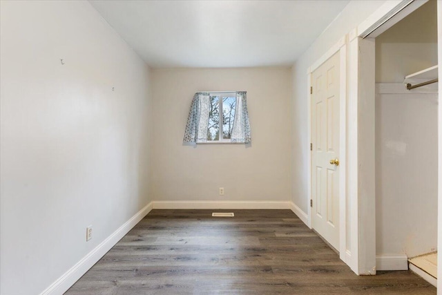 unfurnished bedroom featuring wood finished floors and baseboards
