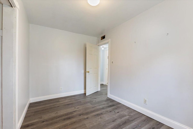 empty room with baseboards and wood finished floors