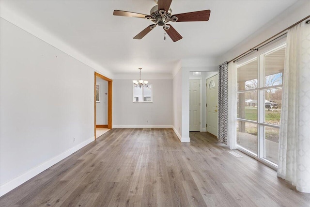 interior space featuring baseboards, crown molding, ceiling fan with notable chandelier, and wood finished floors