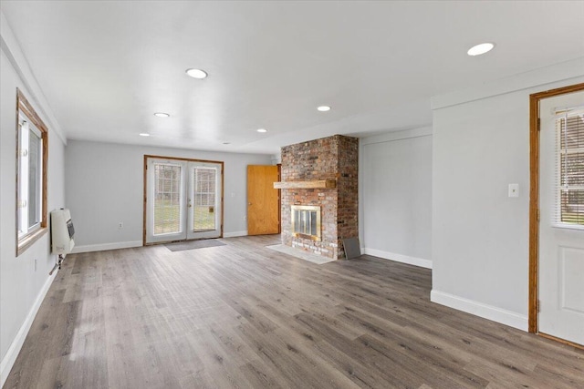 unfurnished living room with recessed lighting, heating unit, wood finished floors, and a healthy amount of sunlight