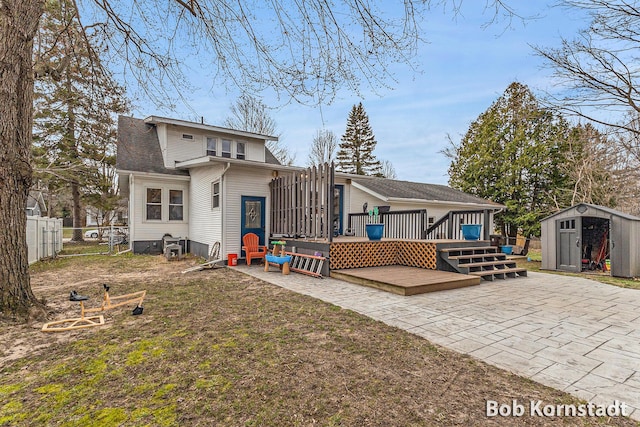 back of property featuring fence, an outdoor structure, a patio, and a storage unit