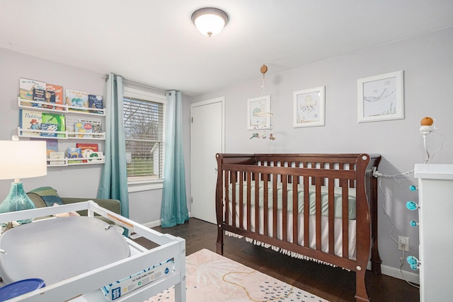 3804 Lincoln Ave, Saint Joseph, MI 49085 - bedroom featuring a crib, baseboards, and wood finished floors