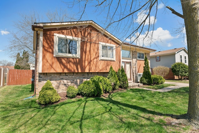 bi-level home with fence and a front lawn