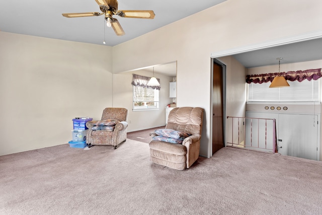 living area with carpet and ceiling fan