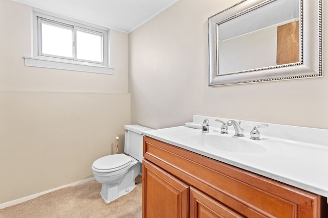 half bath with baseboards, vanity, and toilet