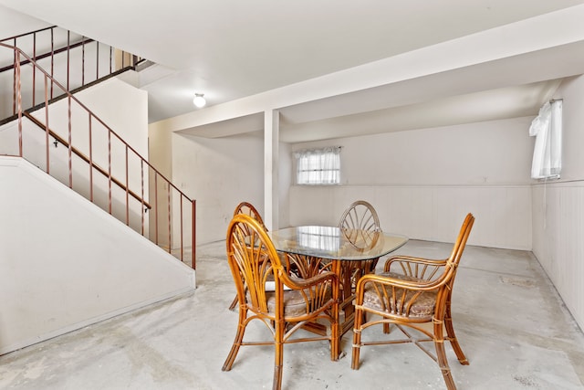 dining room with unfinished concrete flooring and stairs