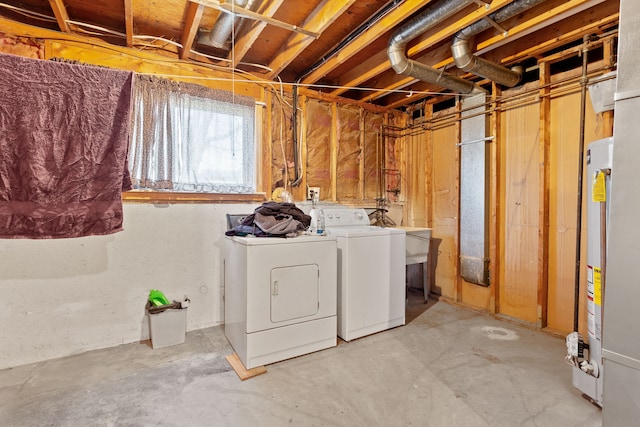 clothes washing area with washing machine and dryer, gas water heater, and laundry area